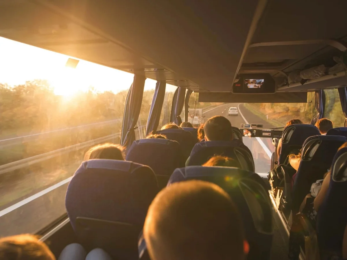 Passengers travelling in a motor coach at sunset.
